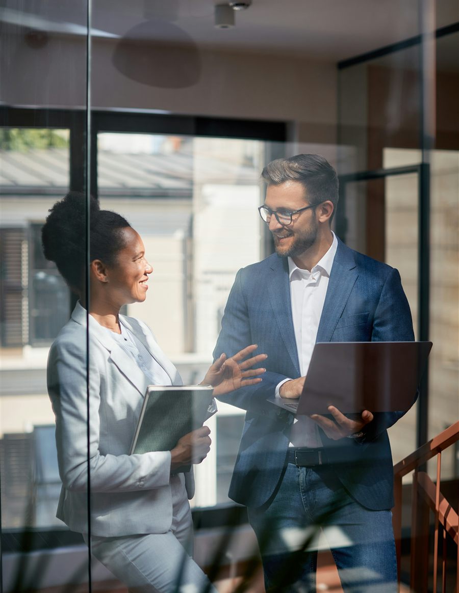 Deux professionnels échangent dans un bureau vitré